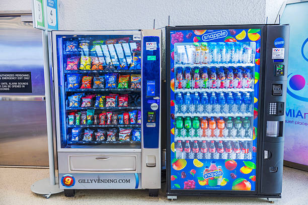 Close-up-view-of-vending-machines-with-snacks-and-Snapple-drinks-standing-in-bright-airport-terminal_1776064341