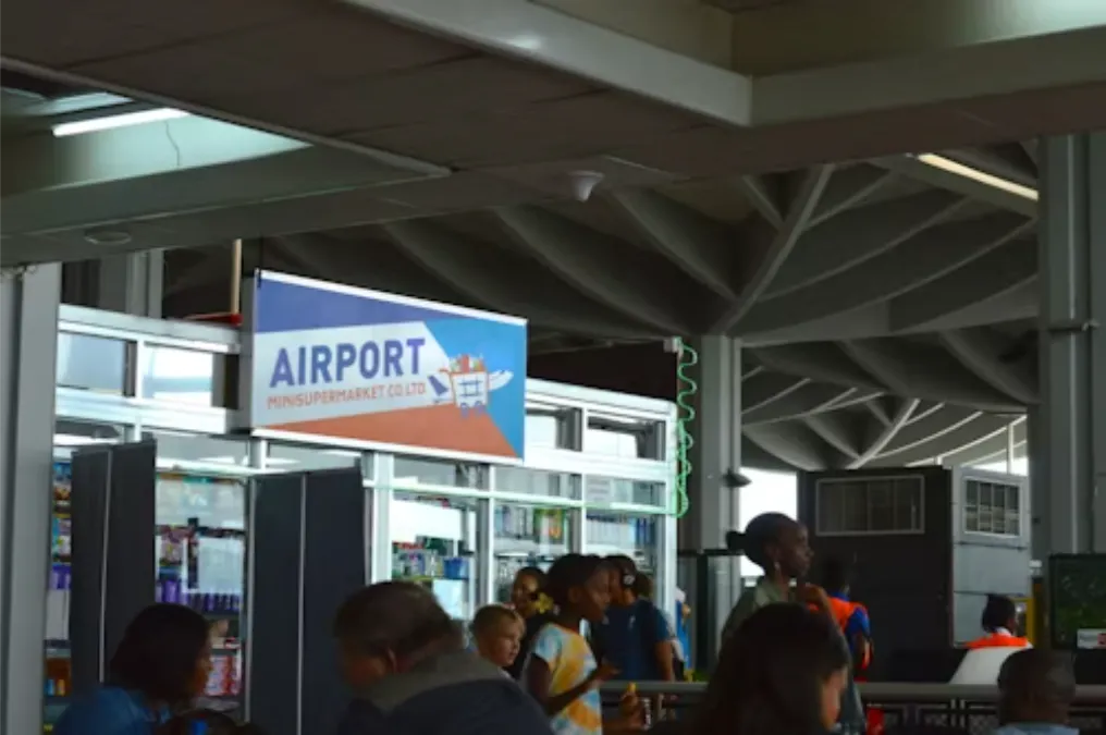 Persone in aeroporto vicino a un cartello
