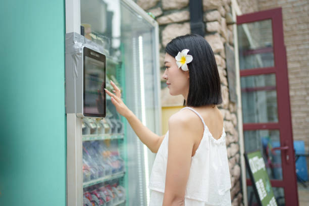 スマート自動販売機を利用する若い女性